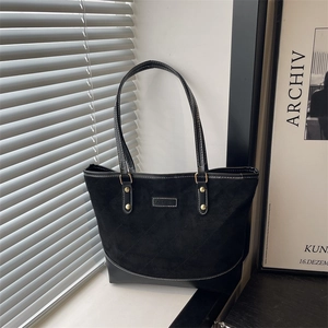Quilted black tote bag with suede patchwork and top handles for daily commuting