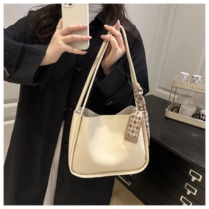 Detail of off-white tote bag featuring elegant plaid silk scarf and slender handles