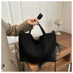 Detail of black woven tassel bag with leopard print texture and dual straps
