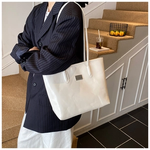 Grand sac cabas blanc en cuir brillant porté à l'épaule pour un style quotidien chic
