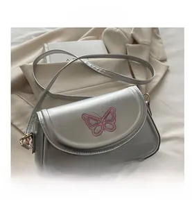 Details der silbernen PU-Tasche mit rosa Schmetterlingsstickerei und Metallschnallen