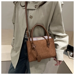 Brown dual-texture crossbody bag detail with Fashion & Bags print and gold hardware