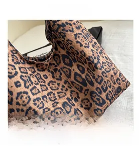 Close-up of leopard print tote bag with soft texture and wide black shoulder strap