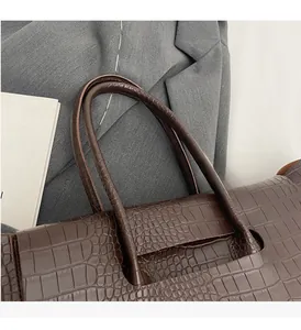 Dettaglio della pelle con trama a coccodrillo marrone scuro su una borsa business