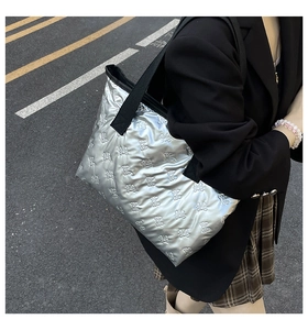 Close-up of silver tote bag featuring metallic finish and butterfly quilted texture