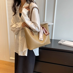 Detail of light khaki tote bag with white contrast stitching and fashion silk scarf