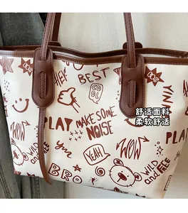Close-up of graffiti print tote bag with bear motifs and dark brown trim accents
