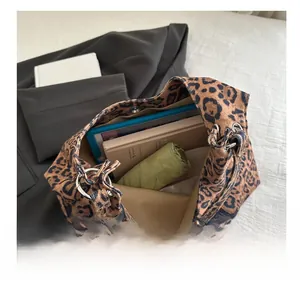 Macro view of leopard print tote bag interior showing large capacity for books and umbrella