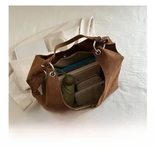 Interior view of brown suede tote bag showing large capacity for books and umbrella