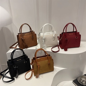 Retro matte patchwork tote bags in five colors displayed on white geometric platforms
