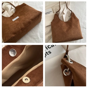 Detail view of brown suede tote bag featuring metallic magnetic closure and silver hardware