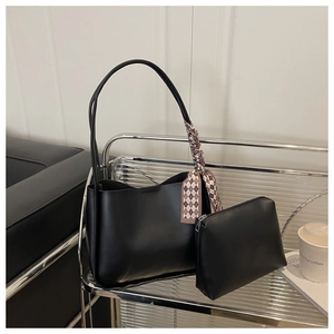 Detail of black faux leather tote bag with an elegant diamond pattern silk scarf accent