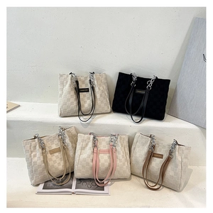 Group of colorful checkerboard tote bags with metal chain straps on display