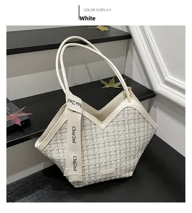 Detail of white tweed tote bag featuring checkered weave and V-cut design on top edge