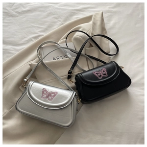 Détail de la broderie papillon rose sur les sacs à bandoulière carrés argentés et noirs