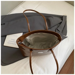 Détail de l'intérieur du cabas en cuir marron avec poche zippée et élément métallique
