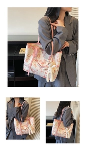 Detail of canvas tote bag with graffiti prints, pink leather trim and bunny charm