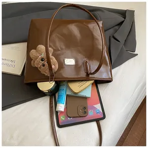 Vue à plat d'un cabas en cuir marron montrant un grand espace pour les essentiels