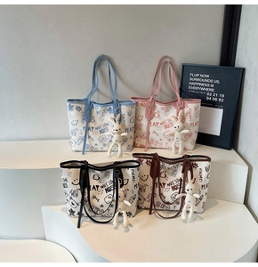 Detailed view of canvas tote bags with graffiti prints and cute bunny plush pendants