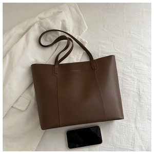 Detail of dark brown tote bag in smooth faux leather with gold fashion lettering