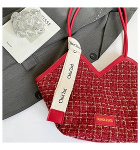 Detail der roten Tweed-Tasche mit Chia'2nd-Band auf einem grauen Anzug-Hintergrund