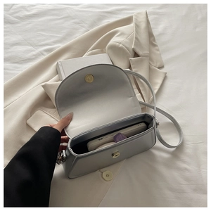 Détail du sac bandoulière gris montrant l'espace pour téléphone et cosmétiques