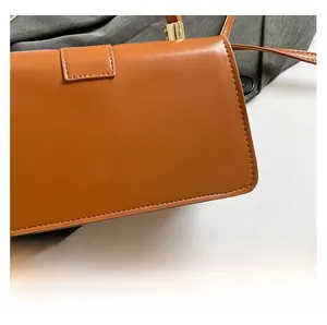 Detail shot of smooth caramel PU leather texture on a minimalist rectangular handbag