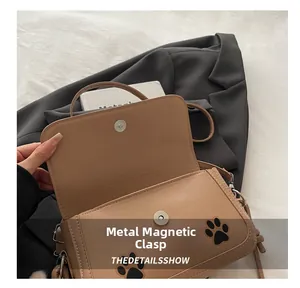 Detail view of the magnetic closure and interior of the brown cat-pattern crossbody bag