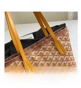 Detail of the Y-pattern canvas underarm bag with yellow leather handle and fine stitching