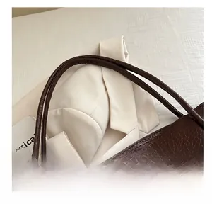 Detail of comfortable crocodile-embossed handle on dark brown large tote bag