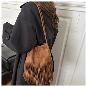 Détail du sac seau bohème en daim marron avec de longues franges et une bandoulière