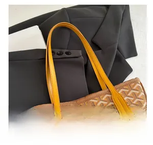Close-up of yellow leather handles and geometric pattern on the tote shoulder bag
