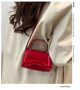 Macro detail of glossy red patent leather mini square bag with unique curved base design