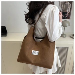 Brown suede tote bag with fashion label shown in a stylish home office setting