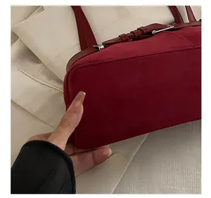 Detail view of the precision stitching on a vintage burgundy suede shoulder bag