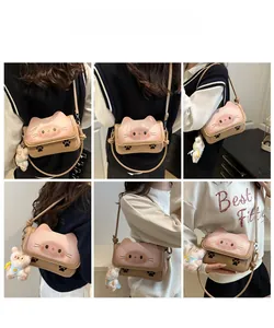 Detail view of cartoon cat crossbody bag with cute paw prints and plush bunny charm