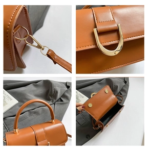 Detailed close-up of brown leather bag showing gold D-ring and magnetic closure