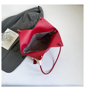 Interior detail of large red faux leather tote bag showing spacious lining and slim straps