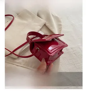 Close-up of a glossy red patent leather handbag with polished mirror finish texture