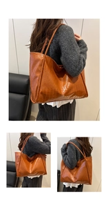 Detail of dark brown tote bag with crocodile pattern and slim dual shoulder straps