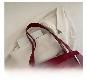 Detailed macro view of dark red suede handbag featuring silver buckle and leather strap