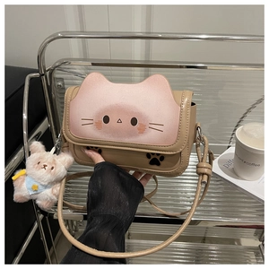Detail of cute cat face pattern on khaki and pink crossbody bag with rabbit charm