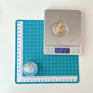 Close-up of a 3D bear and crab phone socket showing 21.2g weight on a scale