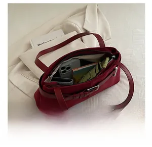 Detailed interior of burgundy tote bag showing large capacity for phone and wallet