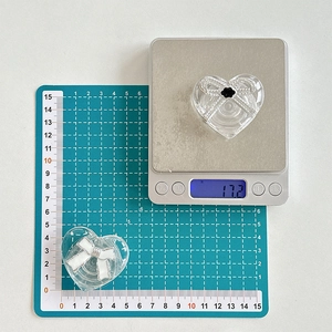 Macro view of transparent heart phone grip with a 3D bow design on a digital scale