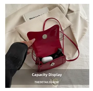 Detail showing red patent leather mini bag interior space with lipstick and earbuds