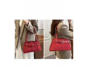 Detail showing the red suede shoulder bag with a stylish belt buckle design in use