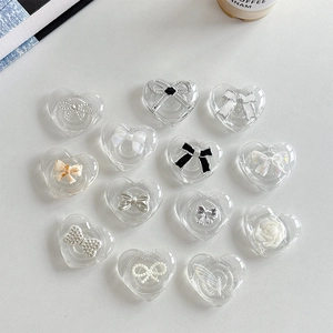Transparent heart-shaped phone grip stands with various decorative bow and flower designs