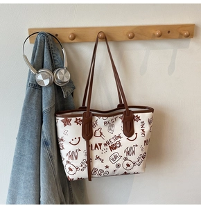 Detail of white graffiti tote bag with brown straps and cute bear pattern print