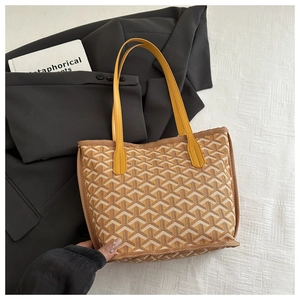 Detail of printed tote bag featuring a yellow leather handle and geometric patterns